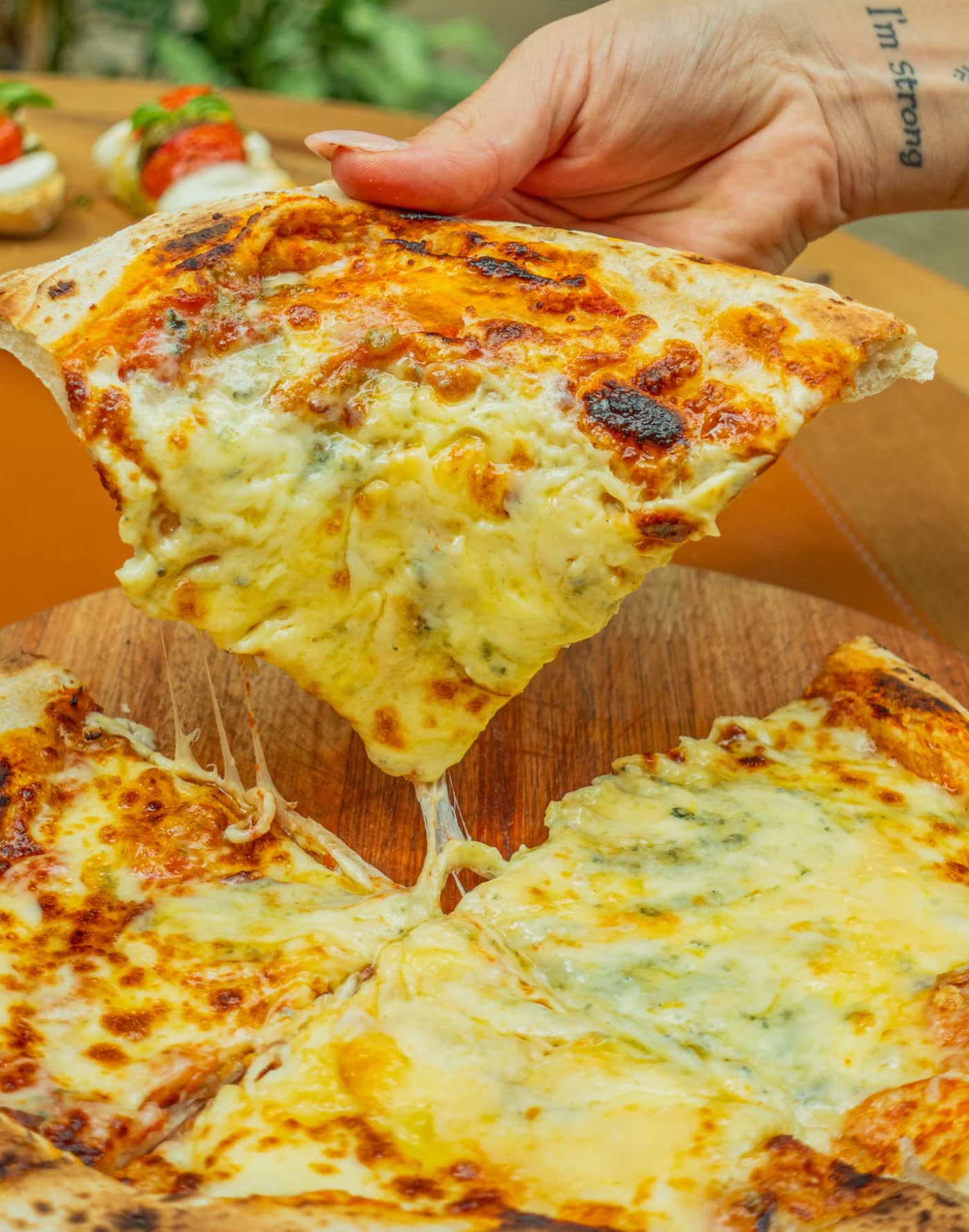 Cheese pull on a slice of quattro formaggi pizza