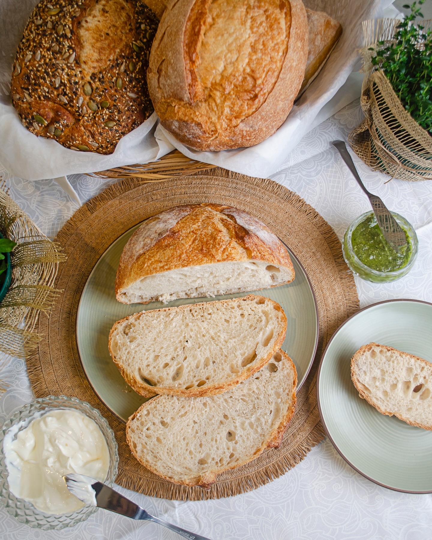 Artisan breads, pesto and cream cheese styled on a table